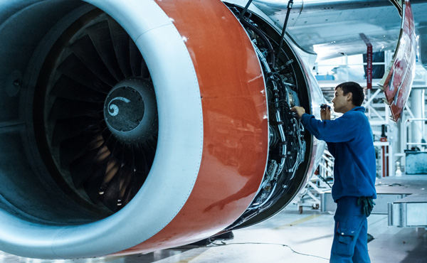 aircraft engine maintenance technician inspecting a jet engine with detailed components showing and focus on precision work