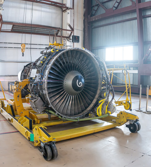 jet engine on a yellow dolly in a hangar showcasing advanced technology and engineering with 12 turbine blades visible