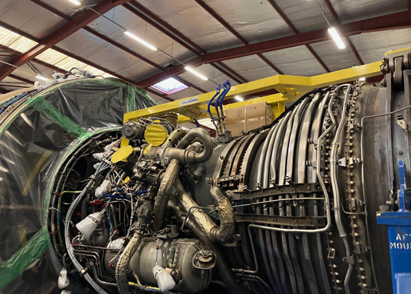 detailed view of a large aircraft engine with various components including pipes and mechanical parts in an industrial setting showcasing advanced engineering and maintenance processes related to aircraft and jet propulsion systems
