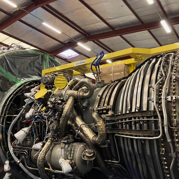 aircraft engine with various components visible in a hangar setting detailing advanced machinery and technology related to aviation