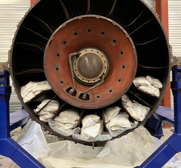 jet engine turbine showcasing internal components and three packaged items for maintenance